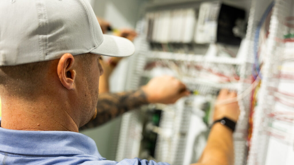 Image of a man working on an electrical panel.