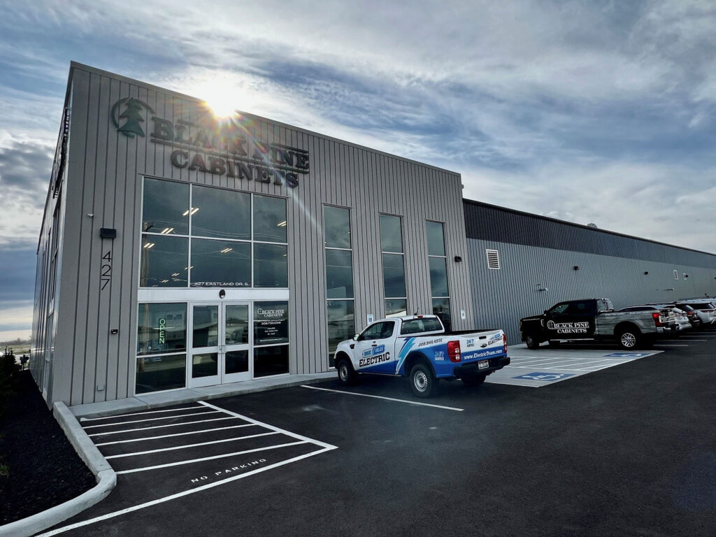 External image of an office building with "Black Pine Cabinets" shown on the side of it. In front of the door, a Magic Valley Electric truck is parked.
