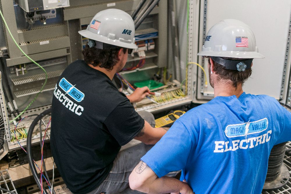 Image of two MVE employees working on electrical services.