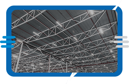 Interior view of a large industrial building’s ceiling, showing metal beams, trusses, and overhead lighting, all framed by a blue border with stylized accent lines.