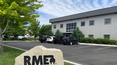 External image of an office building with a rock that has engraved RME on the front of it in the parking lot.