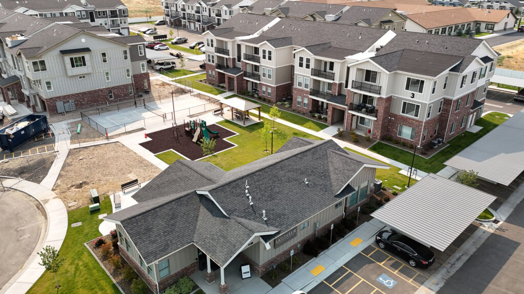 An aerial photo of an apartment complex and their office surrounds a very clean playground. "Latitude 42 Apartments" is written on the office building