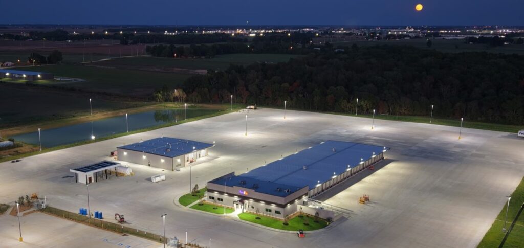 Image of parking lot taken at night. The area is lit up by street lights.