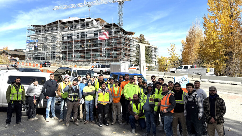 The MVE Team standing in front of a building being built.